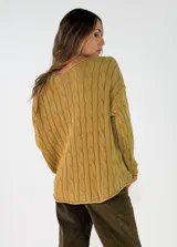 Sweater de punto con diseño de trenzas verticales, cuello redondo y mangas largas. Presenta un corte holgado y cómodo.