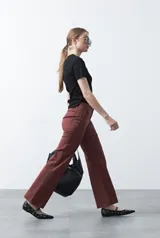 Pantalón de mujer color beige, de corte recto y tiro alto, con costuras frontales marcadas que recorren la pierna.