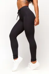 Calza deportiva negra de tiro alto, confeccionada en poliamida con elastano, con costuras laterales visibles y cordón ajustable en la cintura.