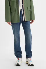 Jeans de denim azul con calce regular, tiro medio y bragueta con botones.