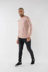 Sweater de tejido de punto en color rosa claro con estampado de pequeñas piñas en tono más oscuro. Presenta escote redondo, mangas largas y puños acanalados.