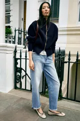 Jeans de tiro medio y corte relaxed fit, color azul con efecto deslavado, diseño de cinco bolsillos y bajo vuelto. Cuenta con cierre frontal de cremallera y botón metálico.