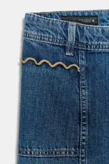 Jeans de tiro alto con corte culotte y pernera ancha. Presenta bolsillos de plastrón en el frente con detalle de pespuntes decorativos en forma de onda y costuras verticales a lo largo de la pierna. Cierre frontal con cremallera y botón metálico.