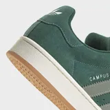 Championes Adidas Campus 00s de diseño retro, confeccionados en gamuza color verde con las icónicas tres tiras laterales en un tono verde más claro. Presentan suela de goma color blanco hueso con base de caucho natural y cierre de cordones al tono.