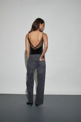 Body de terciopelo negro con escote recto y detalle de encaje transparente en la parte superior. Presenta breteles finos ajustables.