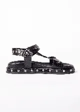 Sandalias de cuero marrón con estampado de cocodrilo y plataforma con tachas plateadas.