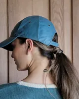 Gorra tipo visera confeccionada en cuero con textura de pelo, diseño clásico con ojales metálicos de ventilación y ajuste posterior.