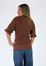 Top de tejido de punto color terracota, con escote en V, cuello camisero y cartera frontal con botones. Presenta mangas cortas con textura calada y puños con volados.