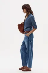 Jean de corte barrel con tiro medio y ajuste relajado. Confeccionado en denim de algodón con un toque de spandex, presenta diseño de cinco bolsillos, cierre frontal con botón y costuras reforzadas en las rodillas.