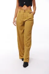 Pantalón de vestir color mostaza, de corte palazzo, con pinzas en la cintura y bolsillos laterales.