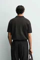 Polo regular fit color verde militar con textura acanalada vertical, cuello solapa con abertura frontal, manga corta y acabados en rib.