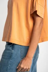 Remerón color naranja de algodón peinado con calce oversize y mangas cortas con dobladillo.