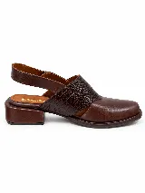 Zapato destalonado de cuero marrón con puntera cerrada, detalles de textura grabada en la capellada y tira ajustable con hebilla en el talón, con taco bajo y ancho.