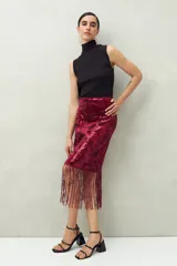 Falda larga de lentejuelas color borgoña con terminación en flecos.