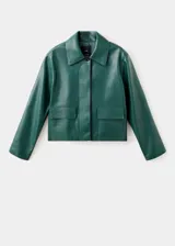 Chaqueta corta de efecto piel en color verde oscuro, con diseño recto, cuello camisero, manga larga y cierre frontal de botones ocultos. Presenta dos bolsillos de parche con solapa en la parte delantera y cuenta con forro interior.