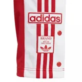 Pantalón deportivo Adidas modelo Adibreak, color rojo con franjas laterales blancas y botones a presión a lo largo de las piernas. Presenta el logo de la marca bordado en la parte superior y etiquetas decorativas en el ruedo.