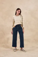 Sweater de punto color beige melange con rayas horizontales en tono dorado brillante. Presenta cuello redondo y puños y ruedo en color marrón.