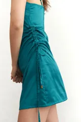 Vestido corto color borgoña, con breteles finos, escote recto y drapeado lateral con cordones ajustables.