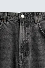 Jeans de denim de algodón, color azul oscuro con efecto lavado. Presentan un corte muy holgado (baggy fit) en toda la pierna y tiro medio. Tienen cinco bolsillos y cierre frontal con cremallera y botón.