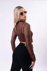 Polera crop de tul marrón con cuello alto y mangas largas, que incluye un top interior a tono.