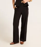 Pantalón de vestir negro, de corte recto, con trabillas en la cintura y cierre tradicional de botón y cremallera.