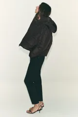 Anorak acolchado de corte corto, resistente al agua y al viento. Cuenta con cuello subido, capucha ajustable con cordones, cierre frontal con cremallera y bolsillos laterales con forro polar. El bajo es ajustable mediante cordones elásticos.
