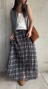 Pollera larga plisada con estampado a cuadros en tonos marrón y celeste, con pretina elástica.