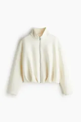 Campera color crema con efecto neopreno, cuello chimenea y cierre frontal. Presenta hombros caídos y pliegues en el bajo.