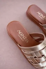 Sandalias de cuero color suela con diseño de tiras anchas entrelazadas en la parte superior y plataforma baja.