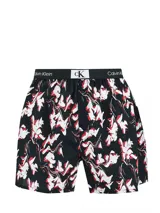 Boxer Calvin Klein de algodón con estampado floral en blanco y rojo sobre fondo negro. Cintura elástica con logo de la marca.
