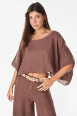 Blusa marrón de lino, de corte holgado y cropped, con escote bote y mangas amplias de tres cuartos.