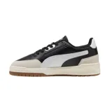 Championes Puma modelo Shuffle Downtown OG, de diseño urbano con base blanca, detalles en negro y suela de goma color caramelo. Presentan refuerzos en gamuza gris en la puntera y el talón, con el logo de la marca en dorado.