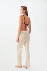 Pantalon de tejido de punto calado en color beige, con corte recto y tiro medio.