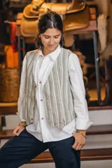 Chaleco reversible de lino, color naranja en el exterior y rayas finas en el interior, con cuello en V y cierre frontal de botones.