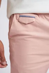 Bermuda tipo chino de gabardina, con cierre y botón frontal, bolsillos laterales y traseros, y dobladillo en el ruedo.