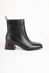 Bota de caña baja color negro, con cierre lateral, punta cuadrada y taco cuadrado.