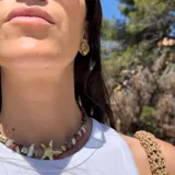 Aros tipo botón dorados con textura irregular que simula la superficie de un molusco.