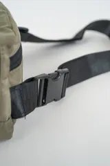 Bandolera color gris con cierre principal y bolsillo frontal con cierre. Cuenta con correa ajustable negra y hebillas de plástico.