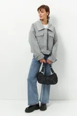 Tapado corto gris de paño, con cuello solapa grande, bolsillos de parche con solapa y mangas largas con puños anchos con presilla y aro metálico.