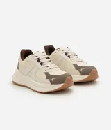 Championes de estilo jogging marca Satinato, con diseño de paneles superpuestos en material sintético y tejido respirable. Presentan suela gruesa, cierre con cordones y tirador trasero.