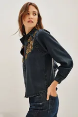 Camisa de liocel color gris oscuro con bordado de flores negras en las mangas largas abullonadas.