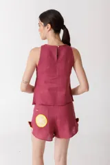 Musculosa color fucsia de lino con botones dorados.