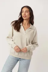 Pullover de tejido liso con mangas de fleece suave, cuello camisero con escote en V y abertura, puños y bajo acanalados.