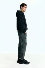 Pantalón de jogging deportivo de corte estándar, color verde militar con estampado de camuflaje pixelado. Confeccionado en tejido funcional DryMove™ con elasticidad en cuatro direcciones. Presenta cintura elástica con cordón de ajuste, bolsillos al bies con cierre y bajos ajustados con cierre y elástico.