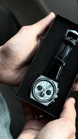 Reloj de pulsera Poedagar modelo 970 Chronograph, con caja de acero inoxidable plateada, esfera plateada con tres subesferas negras y correa de cuero negro con textura de cocodrilo.