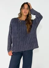 Sweater de punto con diseño de trenzas verticales, cuello redondo y manga larga, de calce holgado.