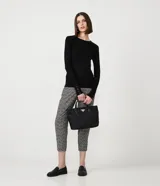 Suéter de punto color rosado, con cuello barco, mangas largas y puños con botones decorativos. El dobladillo también es acanalado.