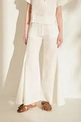Pantalón de lino blanco con corte wide leg y diseño acampanado con vuelo en el bajo.