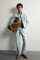 Jeans de corte recto color celeste claro, con tiro medio, diseño de cinco bolsillos, efecto lavado y bajo con acabado irregular deshilachado.