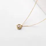 Conjunto compuesto por cadena fina y dije circular con circonia central engastada en oro 18k.